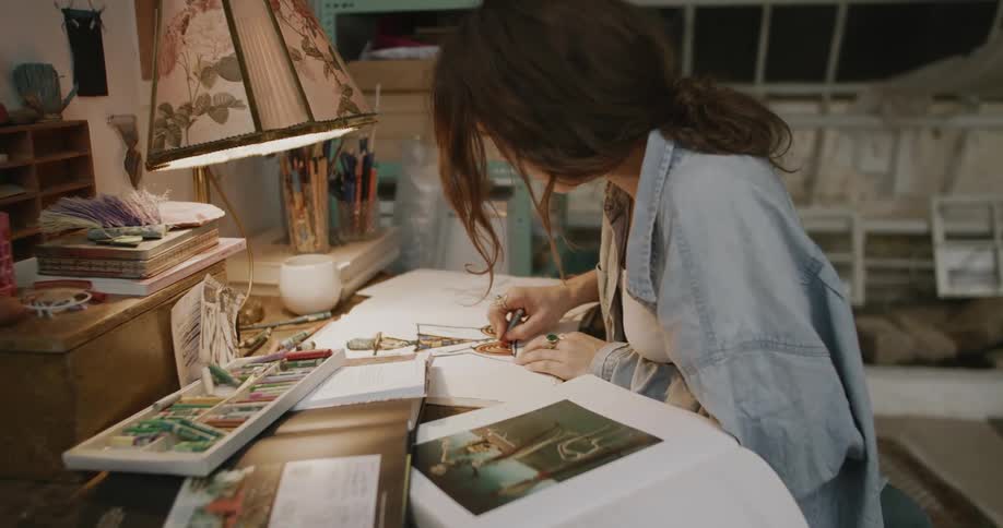 A woman is drawing at her desk