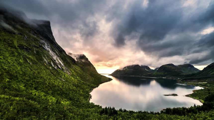 Time lapse landscape with a red sky under mountains with forests