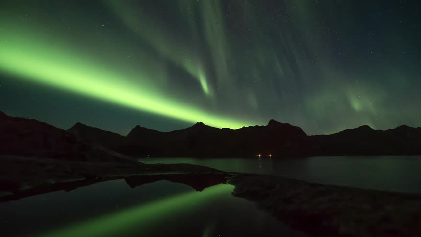 The sky is green with northern lights at night