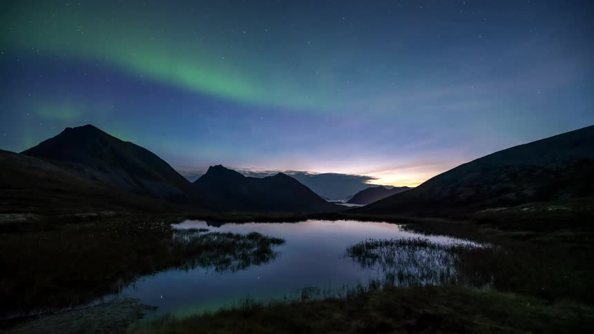 Landscape of a lake and mountains with the sky with northern lights
