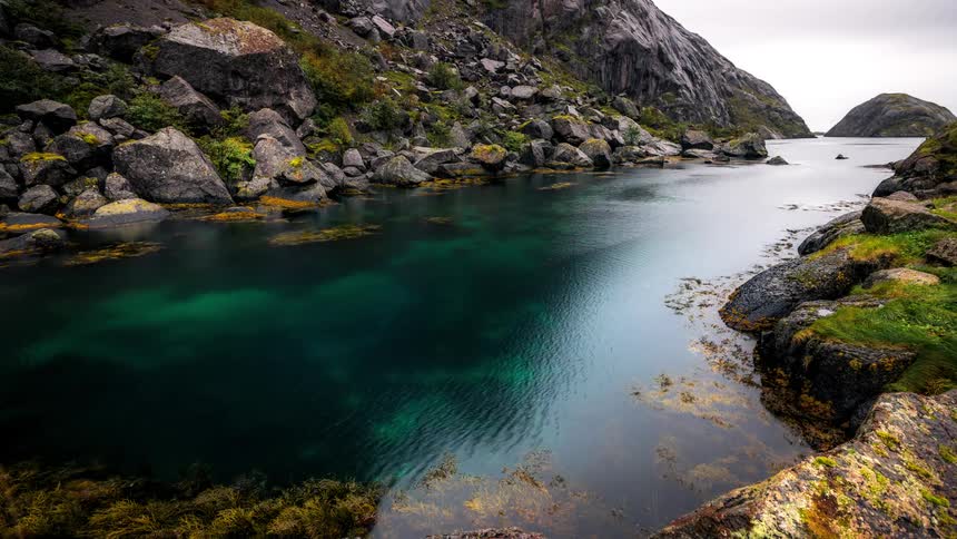 A lake with small ripples and on the edge there are many stones