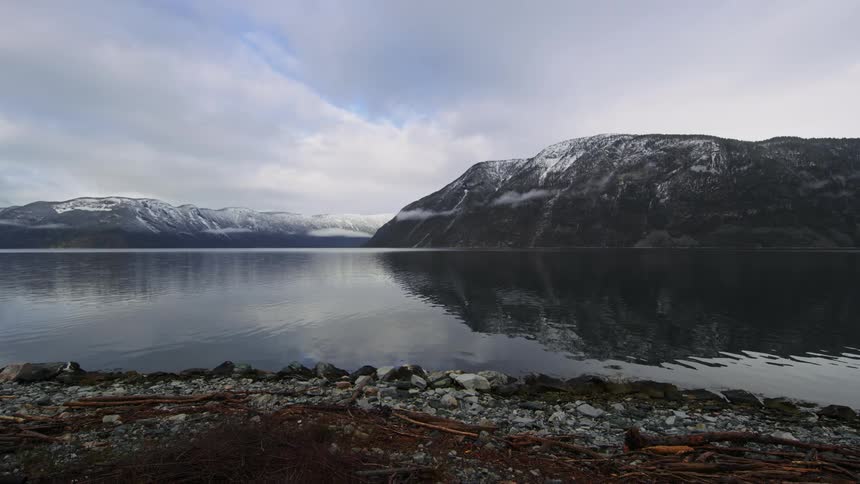 A lake with ripples and in the middle there are some mountains