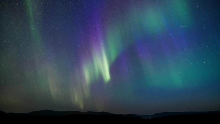 A pastel aurora illuminating light shades a starry night sky