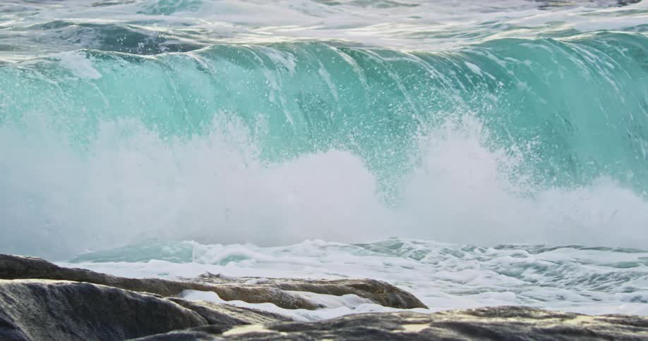 Turquoise sea wave breaking near the shore