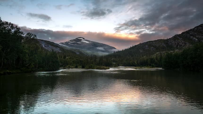 A clip of a mountain close to the river and woods