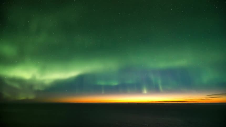 Time lapse view of the northern lights dancing above a flat landscape
