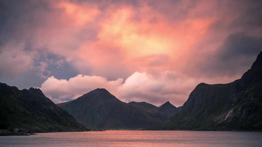 Timelapse landscape of clouds passing over a lake and mountain ranges