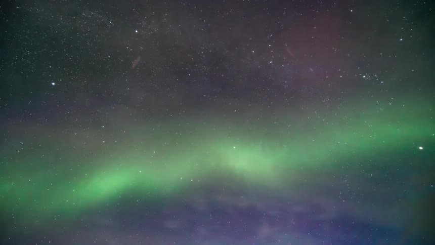 The northern lights with bright green colors in a starry sky