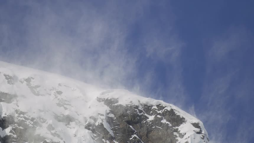 The top of a stone rock formation covered in snow and with a little fog