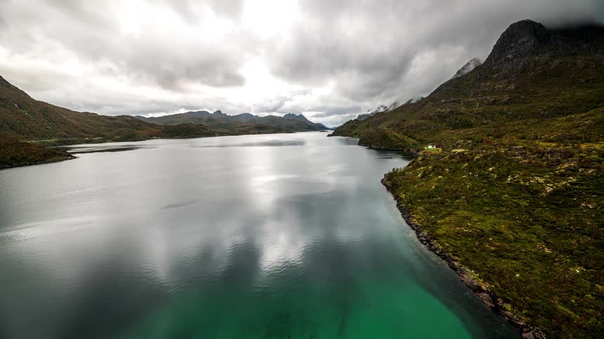 A reflection of clouds that are in the sky in the water of a river