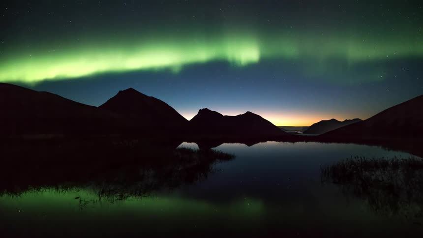 Landscape of a reflective lake with the sky with northern lights