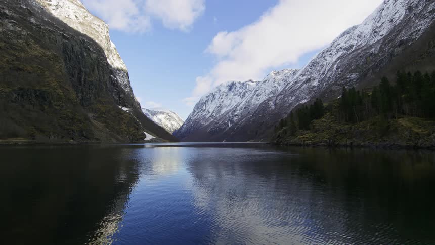 A landscape of a river in the middle of mountains with a snowcovered top