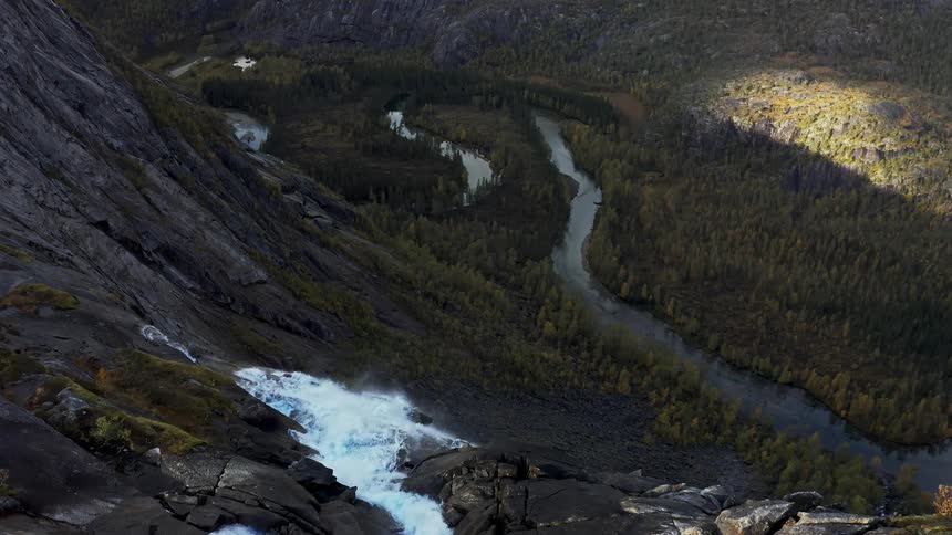 Aerial panorama of a waterfall climbing a huge mountain with access to the forest and river