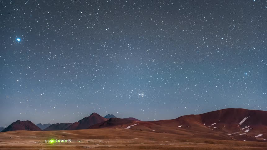 Landscape of mountains with snow and a blue starry sky in timelapse