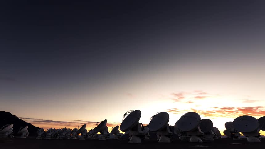 A farm of radio telescopes facing the sky that is full of stars until dawn
