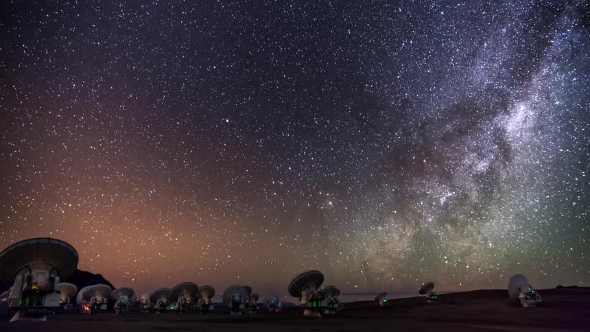 A region with several satellites facing the sky and when it gets dark the sky is full of stars