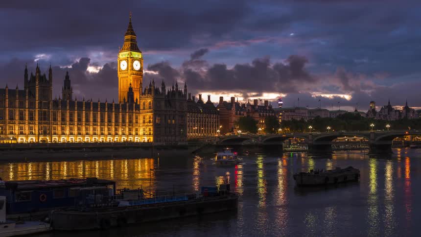 Boats and cars move past londons parliament