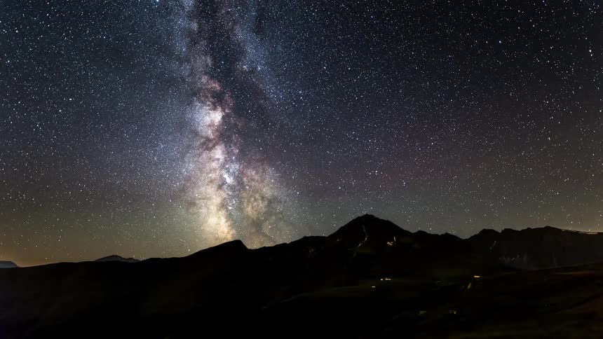 Natural landscape of mountains with the sky darkening with stars and dawning in timelapse