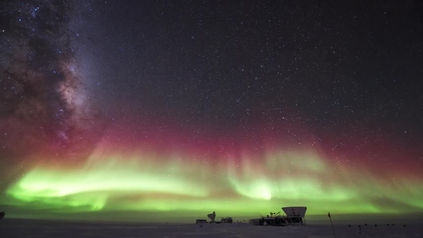 The milkyway and Aurora Australis shine over a research station