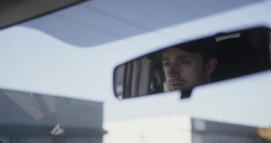 A man drives on a sunny day