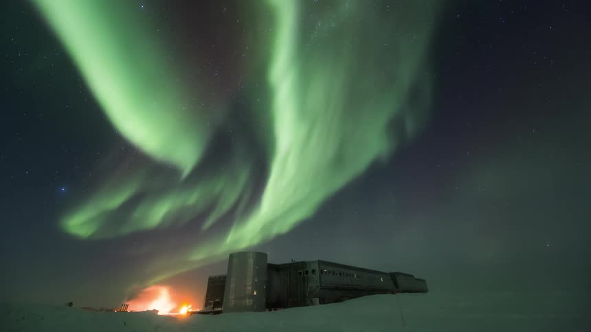 Landscape of a building and a half in the snow with the night sky with the Aurora Australis