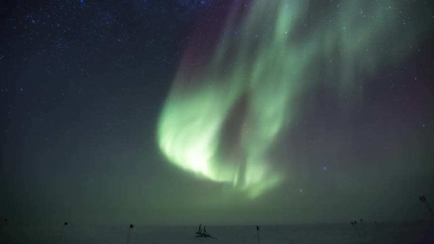 The green Aurora Australis shine above the snow