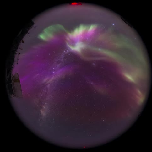 fisheye view of a telescope with purple Aurora Australis