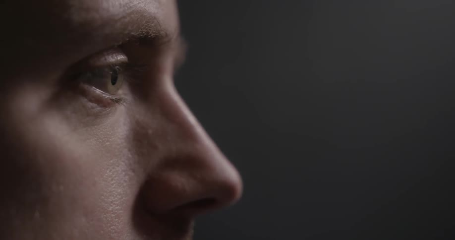 A man looking forward blinks his eyes