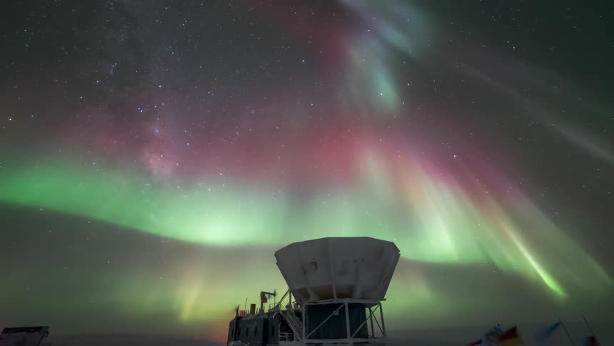 The Aurora Australis shining in the sky and over an observatory