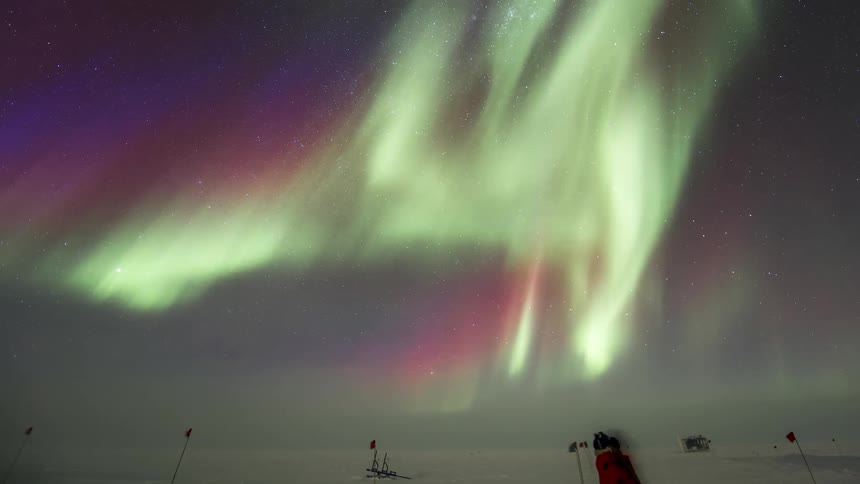 A person wanders out in the snow to see an aurora