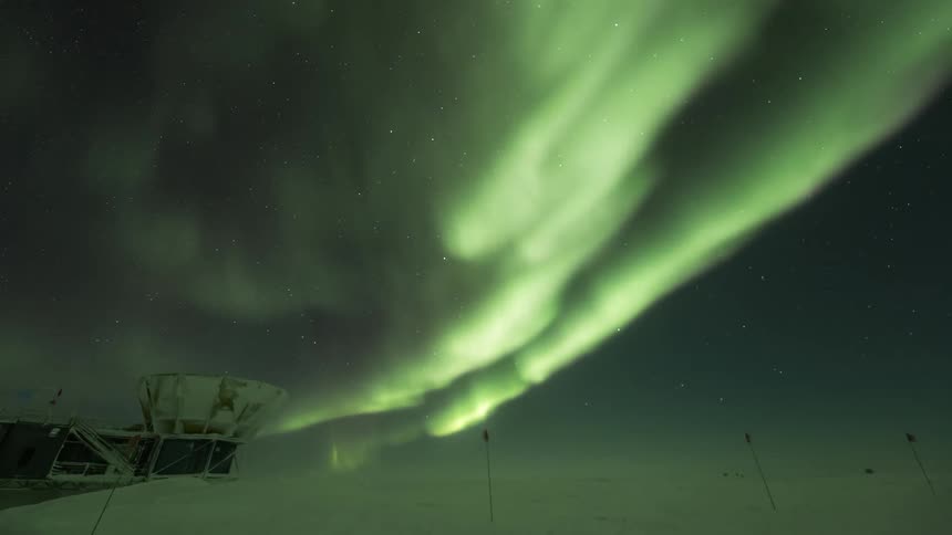 A dense Aurora Australis in the sky over a telescope observatory