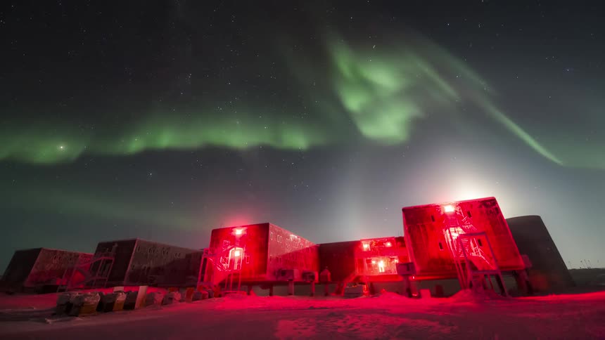 Aurora Australis shining above a reasearch station at night