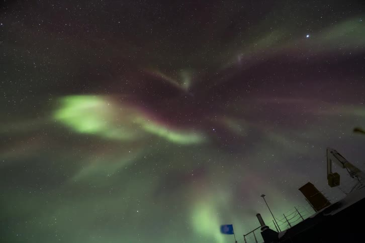 Upward view of a night sky with Aurora Australis