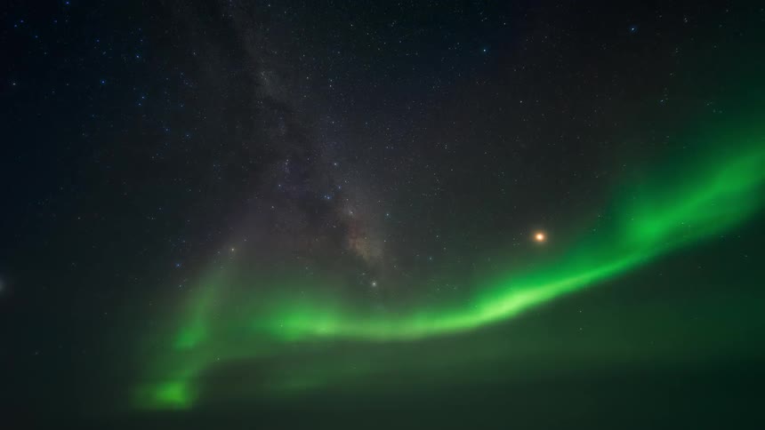 The aurora flashes green in the night sky