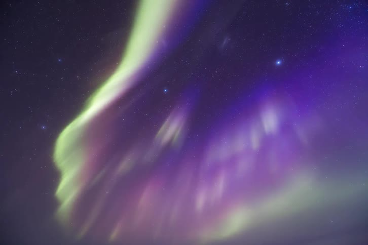 An aurora shimmers in the night sky
