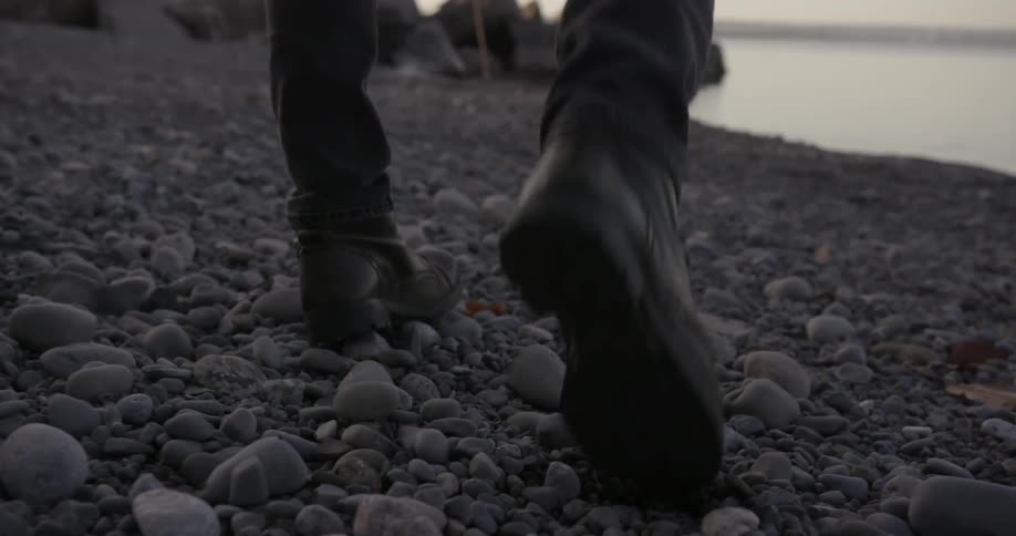 Person walking  gently on a very rocky beach