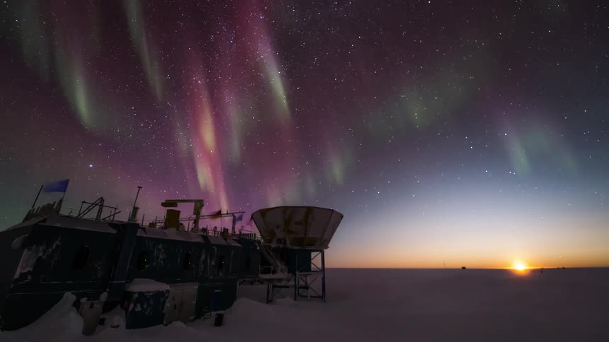 Aurora Australis shining over a research station at dawn