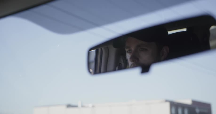 A man drives on a sunny day