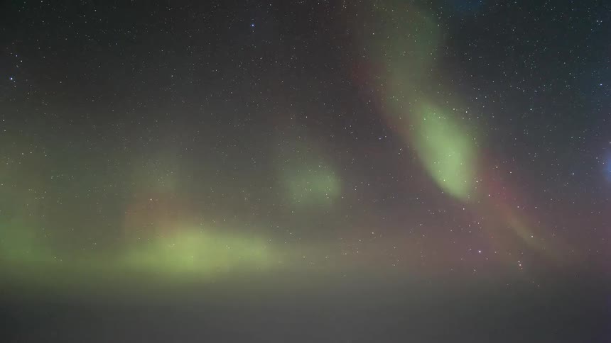 A starry sky with the green glow of an Aurora Australis