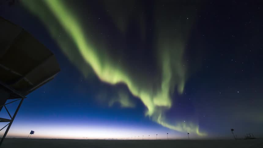 The aurora flows over the satellite dish