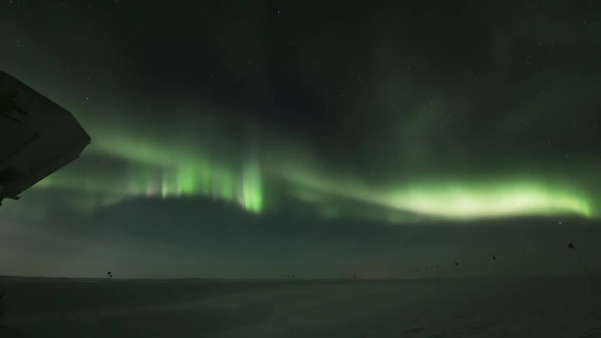 Snowy desert panorama with night sky in timelapse with the Aurora Australis
