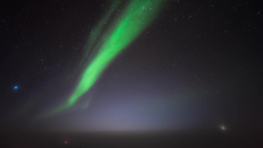 Aurora Australis glows brightly in starry night sky