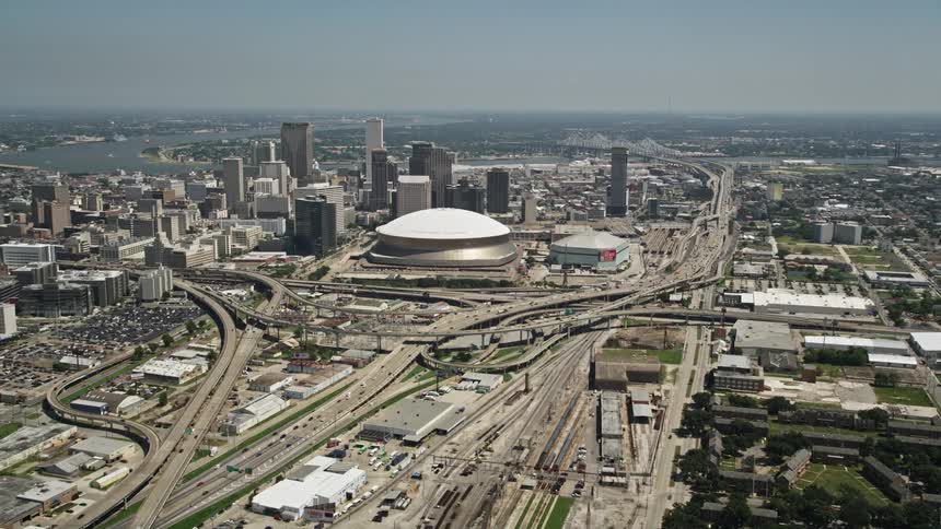 A stadium with a dome roof sits in the middle of a downtown area