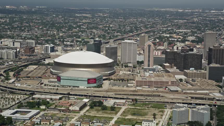 An arena with dome architecture in a city with a busy highway