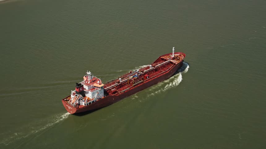 A barge sails up a river
