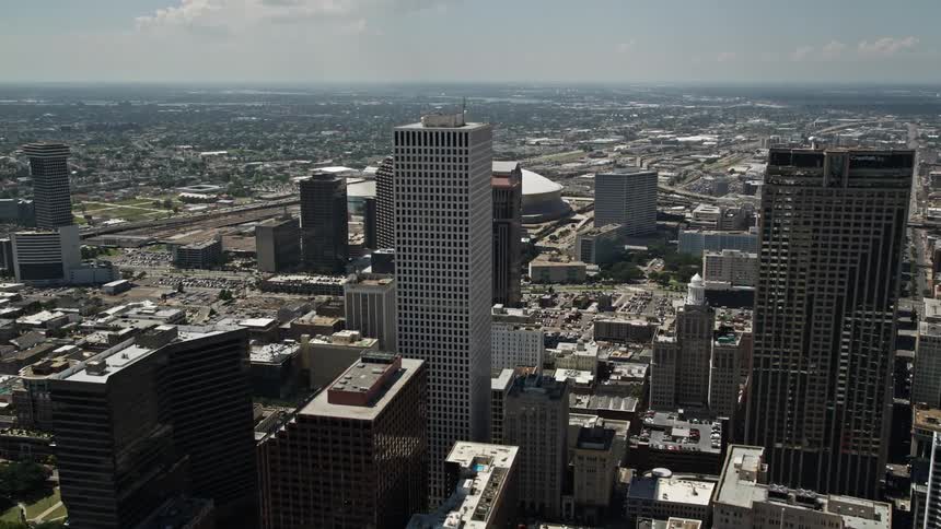 Aerial panorama of large buildings amidst a metropolitan city with a modern stadium globe