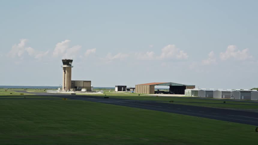 An airport with tower and a plane in a hangar