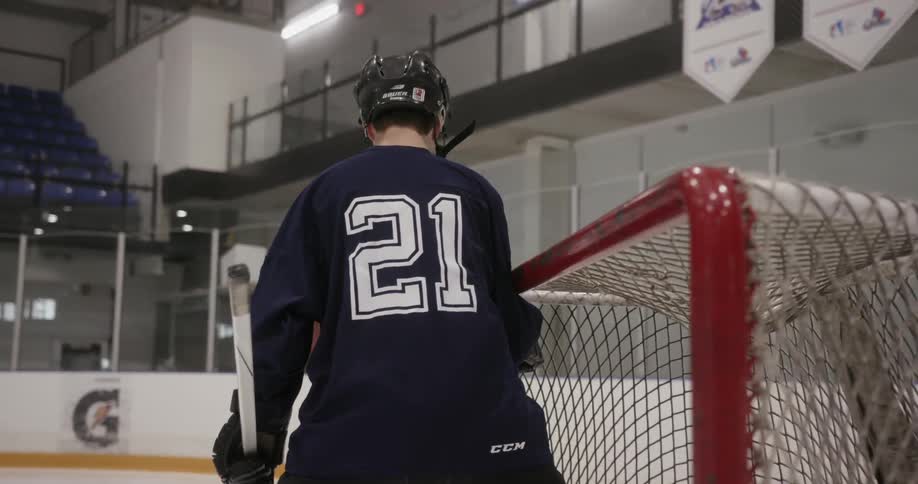 A hockey player moves a hockey goal net