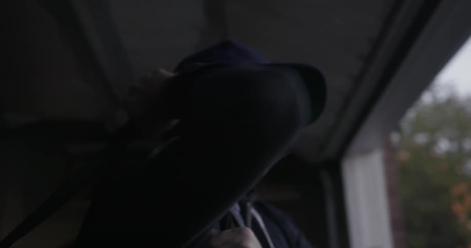 A man wearing a baseball cap shoulders a bag