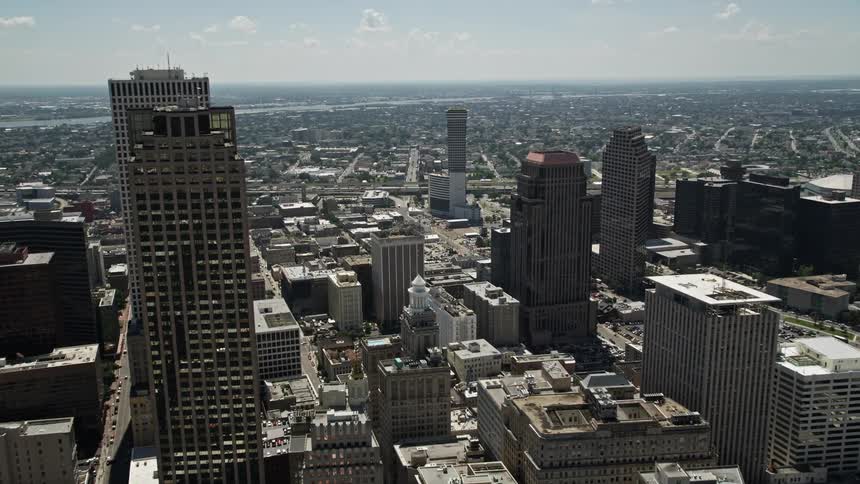 An aerial view of a city with very tall buildings and in the background there is a suburb with small houses
